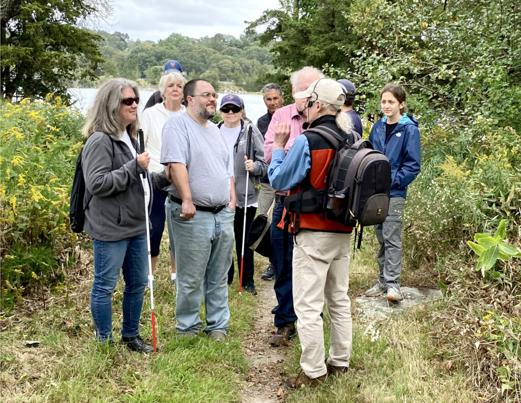 Naturalist Bruce Fellman (back to camera) leads a hike in Stonington’s Knox Preserve for hikers with visual disabilities and their friends.